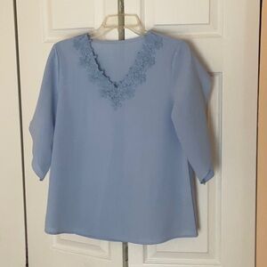 Poly spandex light blue blouse.